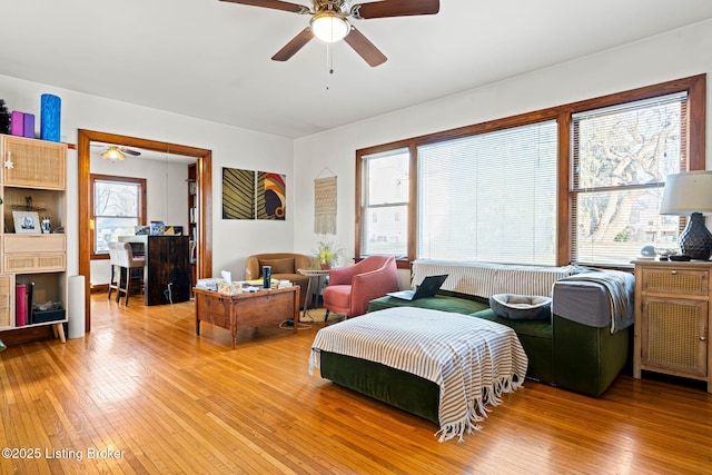 bedroom with ceiling fan, multiple windows, and light hardwood / wood-style flooring