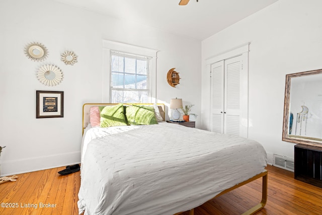 bedroom featuring hardwood / wood-style floors, a closet, and ceiling fan