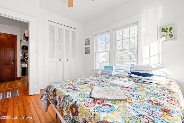 bedroom with hardwood / wood-style flooring, a closet, and ceiling fan