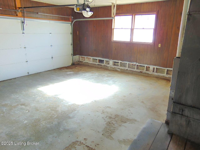 garage featuring a garage door opener and wood walls