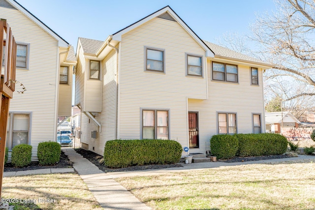 multi unit property with a shingled roof and a front lawn