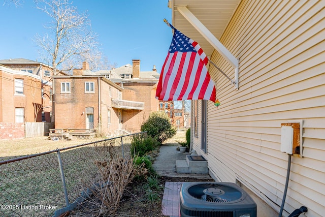 view of side of property with a fenced backyard and central air condition unit