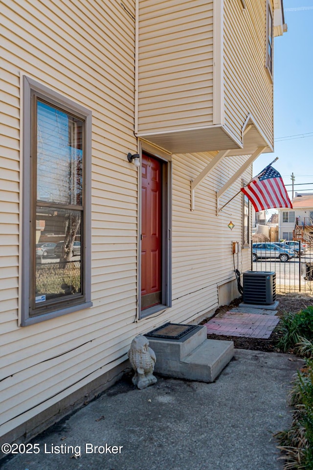 entrance to property featuring central AC and fence