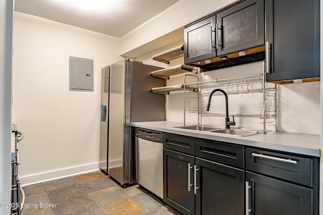 kitchen with electric panel, baseboards, light countertops, stone tile flooring, and stainless steel dishwasher