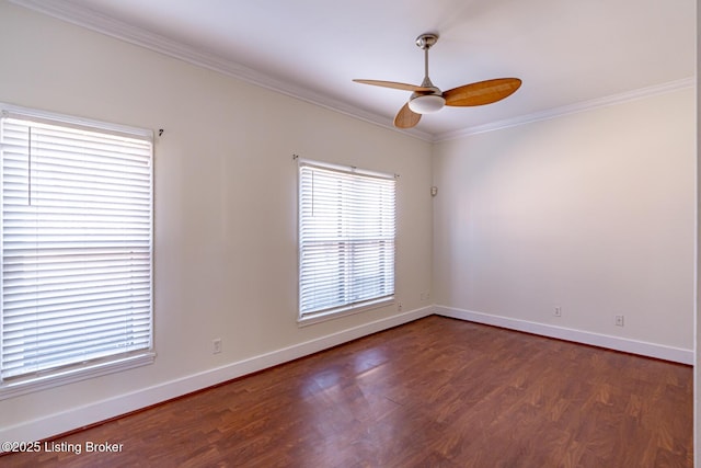 empty room with dark wood-style floors, baseboards, and ornamental molding