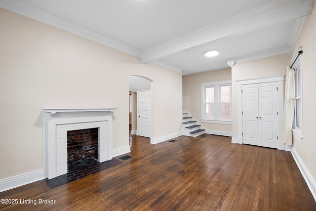 unfurnished living room with beamed ceiling, ornamental molding, dark hardwood / wood-style floors, and a fireplace