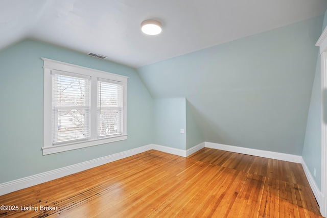 bonus room with wood-type flooring and vaulted ceiling