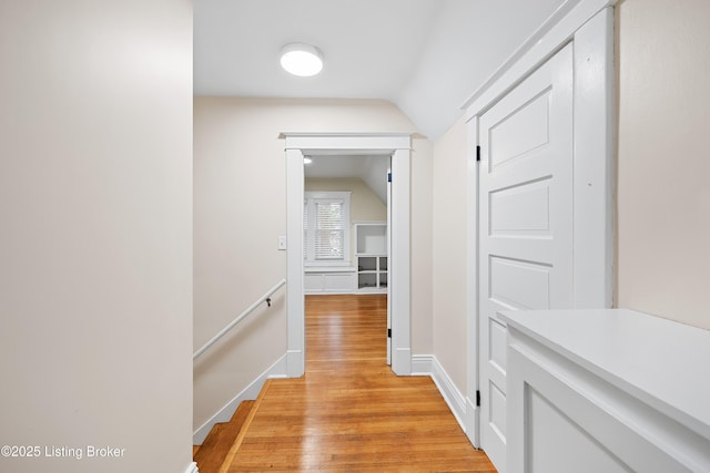 hall featuring vaulted ceiling and light wood-type flooring