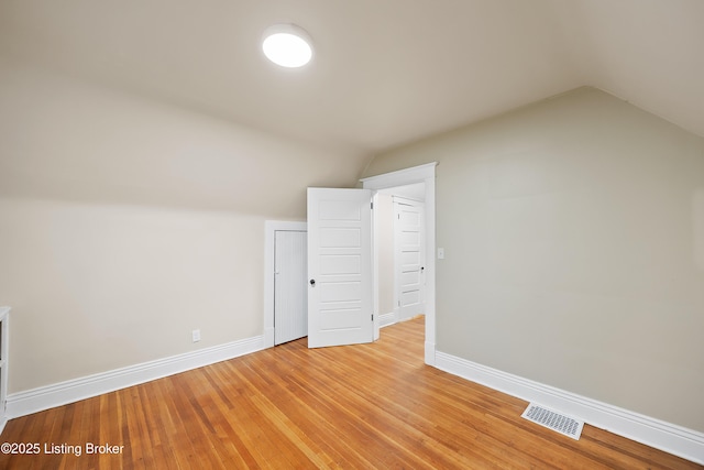 bonus room with lofted ceiling and light wood-type flooring