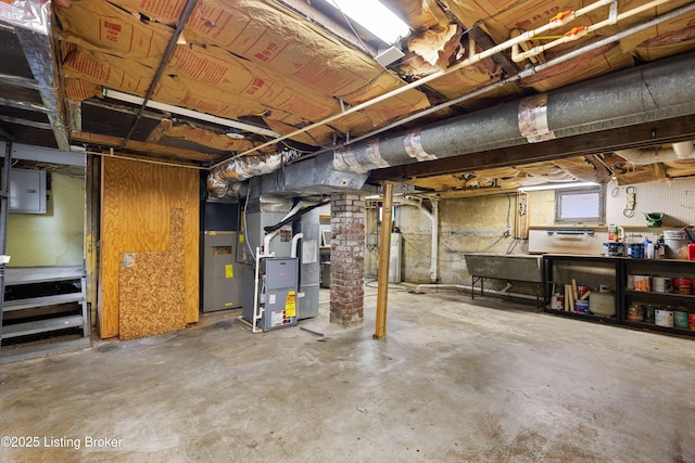 basement with heating unit, electric panel, and water heater