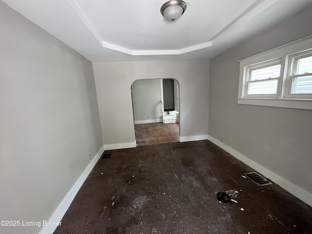 spare room with a raised ceiling