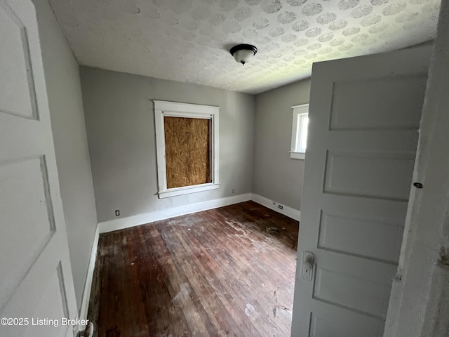 unfurnished room with hardwood / wood-style floors and a textured ceiling