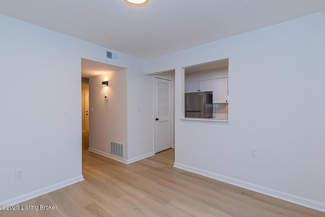 unfurnished room with light wood-type flooring