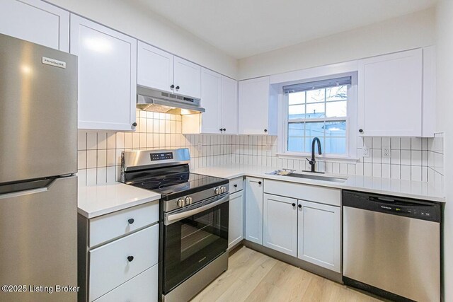 kitchen with backsplash, appliances with stainless steel finishes, sink, and white cabinets