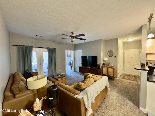 living room featuring ceiling fan, light colored carpet, and a textured ceiling