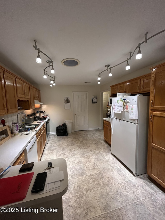 kitchen with tasteful backsplash, sink, and white appliances