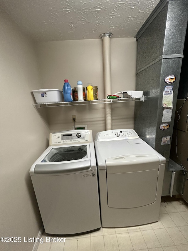 laundry room featuring washing machine and dryer and a textured ceiling