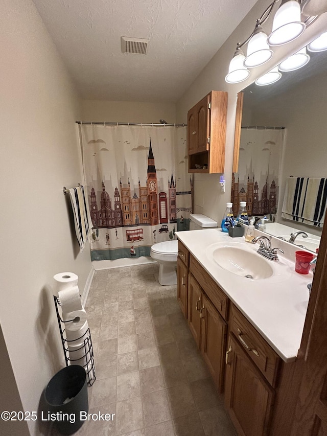 bathroom featuring vanity, a shower with shower curtain, a textured ceiling, and toilet