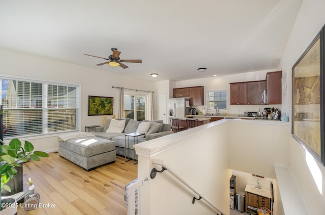 living room with ceiling fan, sink, and light hardwood / wood-style flooring