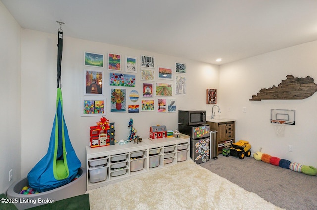 recreation room featuring sink and carpet flooring