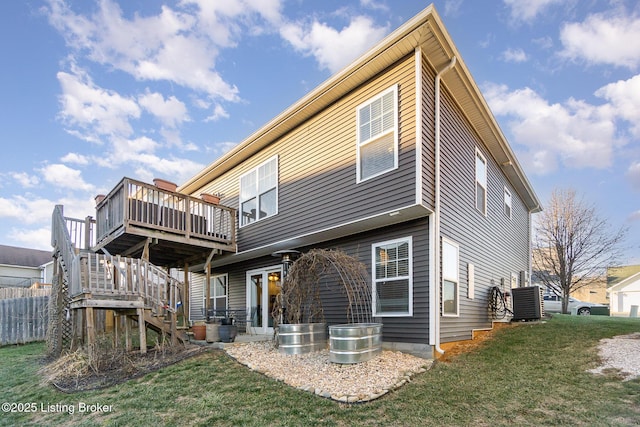 back of property with cooling unit, a lawn, and a deck