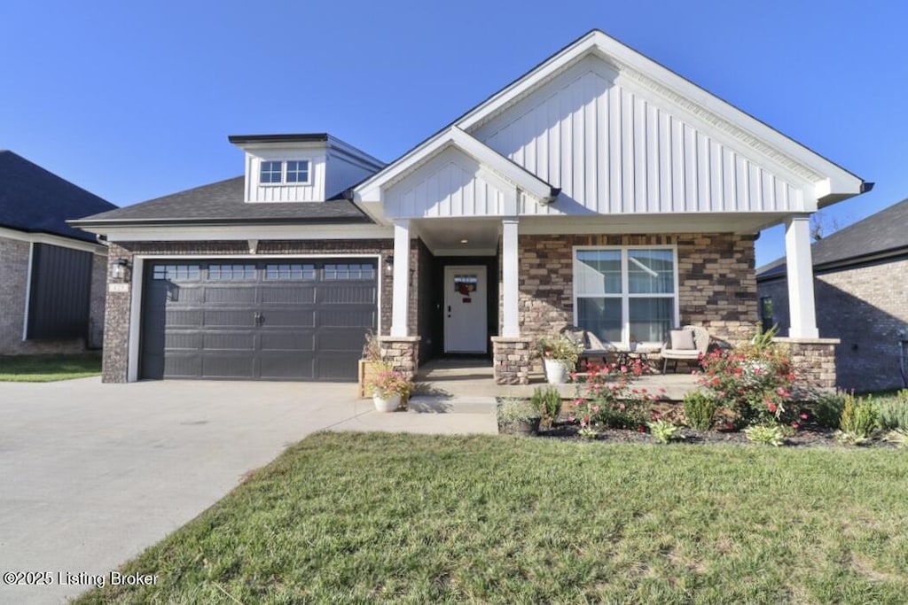 view of front of property with a garage, a front yard, and covered porch