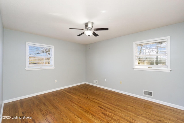 spare room featuring hardwood / wood-style floors, plenty of natural light, and ceiling fan