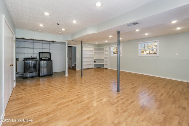 basement featuring washer / dryer and light hardwood / wood-style floors