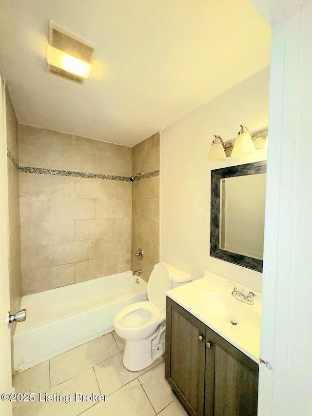 full bathroom featuring tile patterned flooring, vanity, tiled shower / bath combo, and toilet