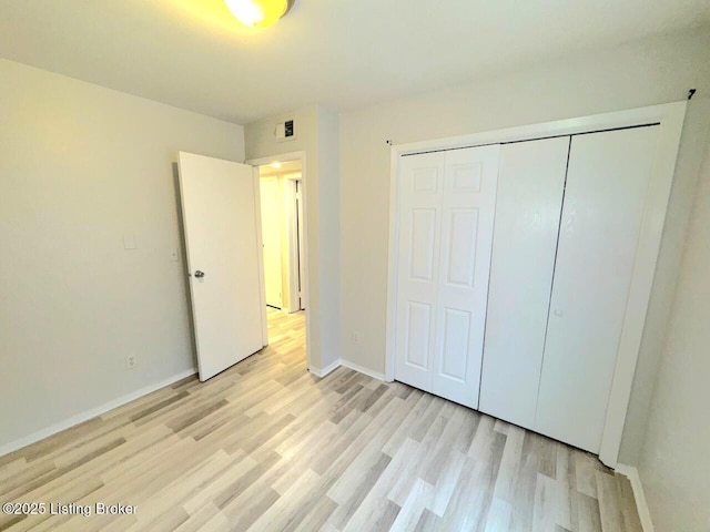 unfurnished bedroom featuring light hardwood / wood-style flooring and a closet