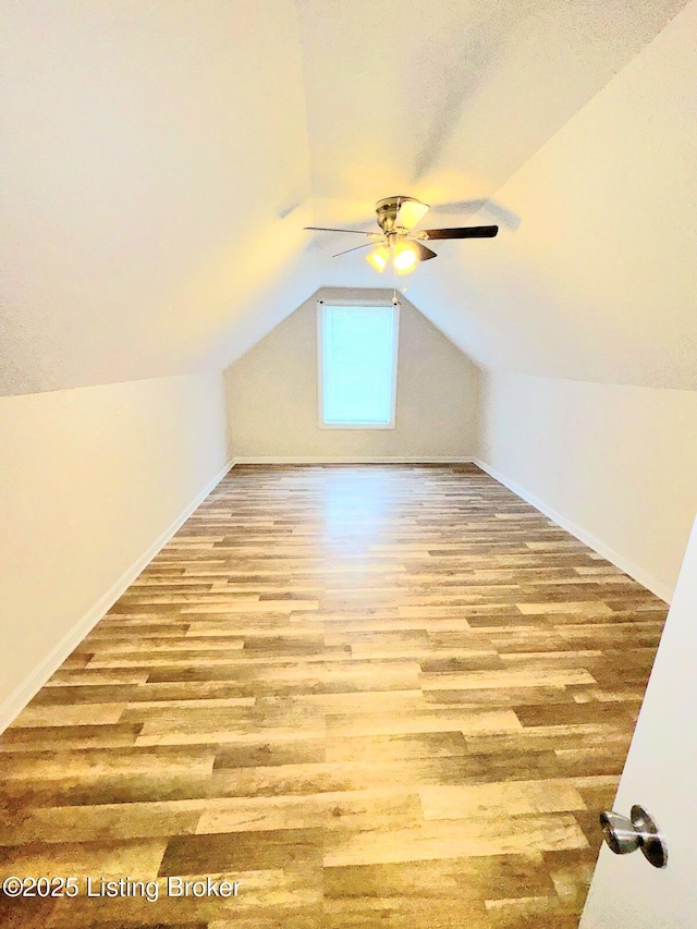 bonus room with lofted ceiling and light wood-type flooring