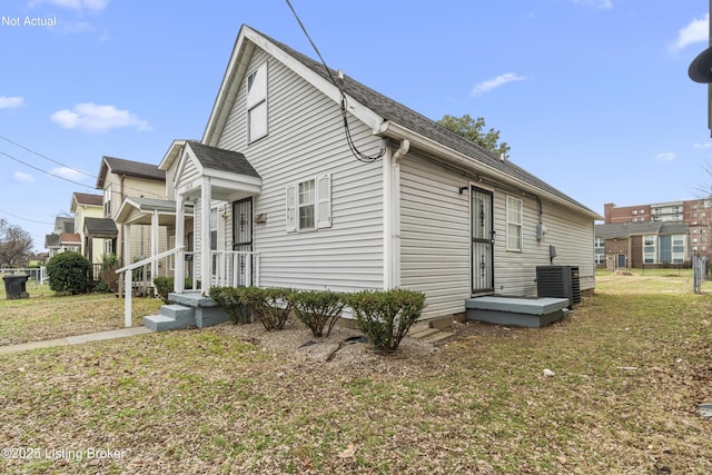 view of home's exterior featuring a lawn and central AC