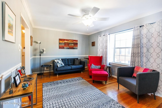 living area with hardwood / wood-style floors, ornamental molding, and ceiling fan