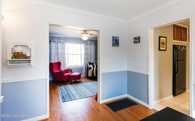 hall with crown molding and light wood-type flooring