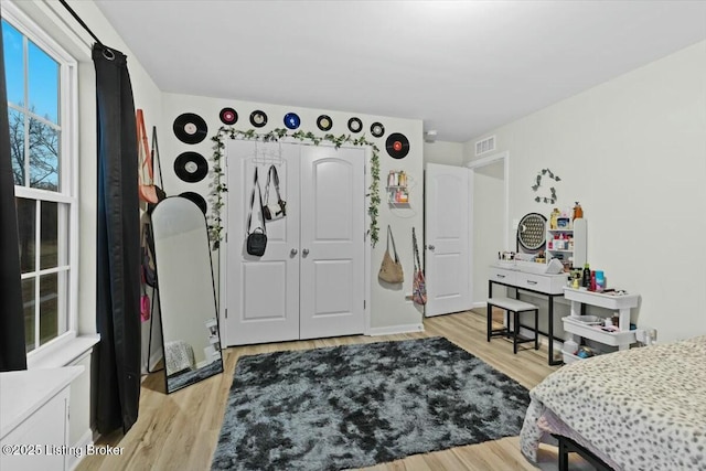 bedroom with light hardwood / wood-style floors and a closet