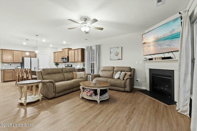 living room featuring ceiling fan and light wood-type flooring