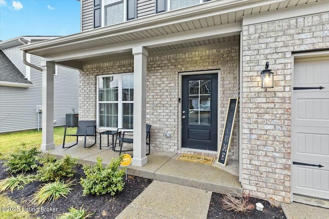 entrance to property featuring a porch and central AC