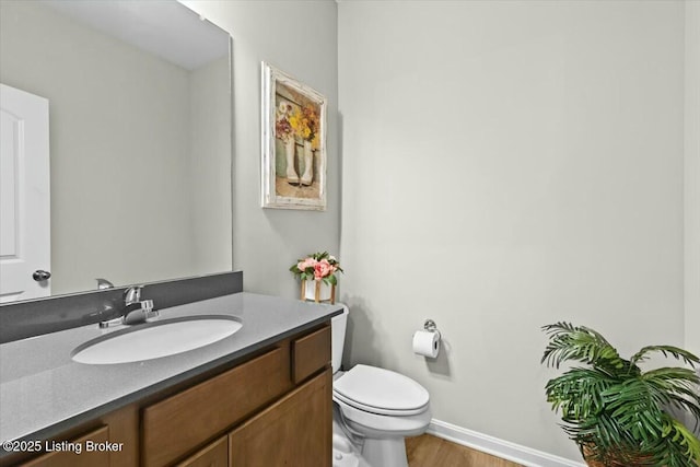 bathroom featuring vanity, hardwood / wood-style flooring, and toilet