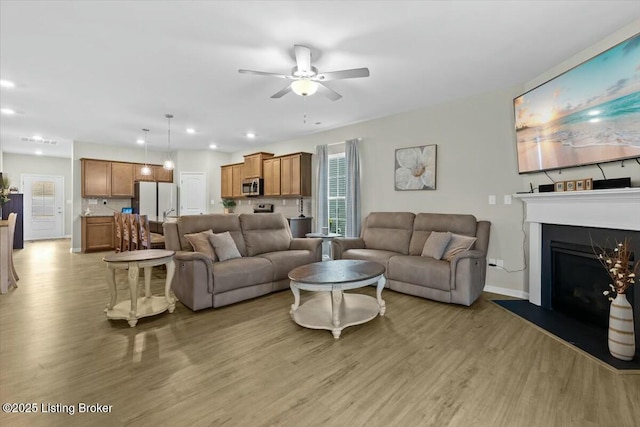 living room featuring ceiling fan and light wood-type flooring