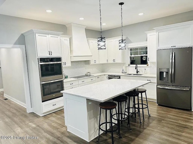 kitchen featuring sink, black appliances, white cabinets, a kitchen island, and custom exhaust hood