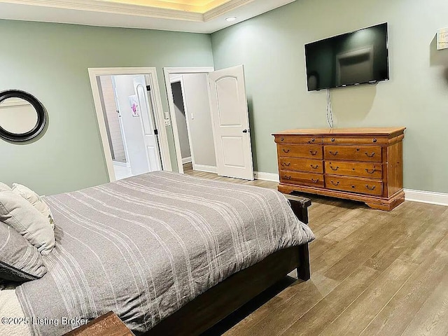 bedroom with crown molding and light wood-type flooring