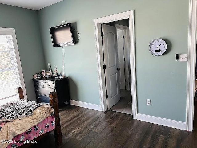 bedroom featuring dark hardwood / wood-style flooring and ensuite bathroom