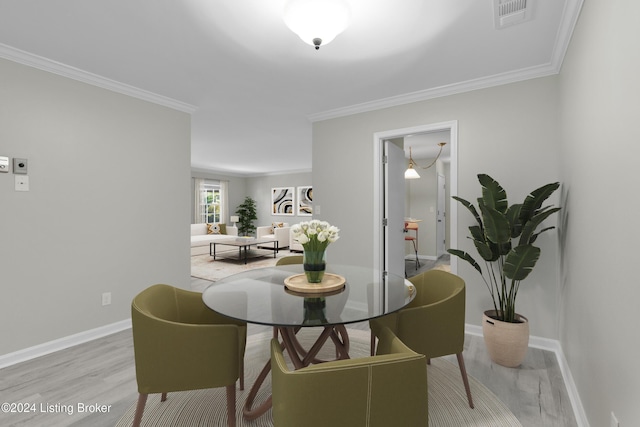 dining room featuring ornamental molding and light wood-type flooring