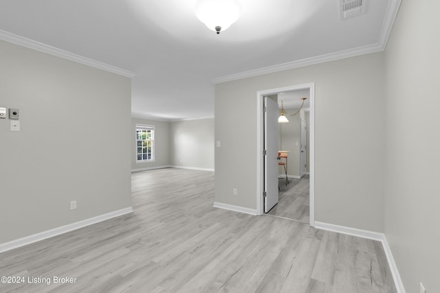 empty room with crown molding and light hardwood / wood-style floors