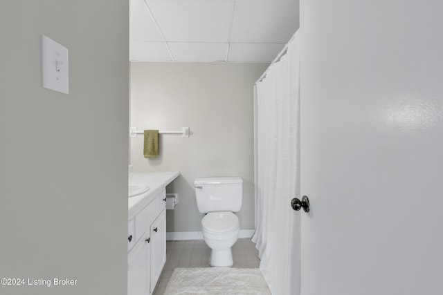 bathroom with vanity, tile patterned flooring, a paneled ceiling, and toilet