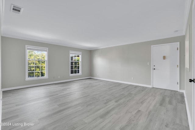 unfurnished room featuring ornamental molding and light hardwood / wood-style flooring