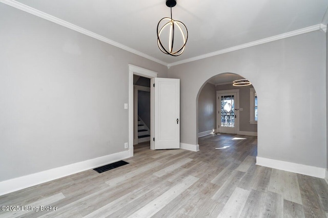 unfurnished room with crown molding, a chandelier, and light hardwood / wood-style flooring