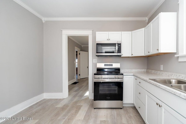 kitchen with white cabinetry, stainless steel appliances, crown molding, and light hardwood / wood-style floors