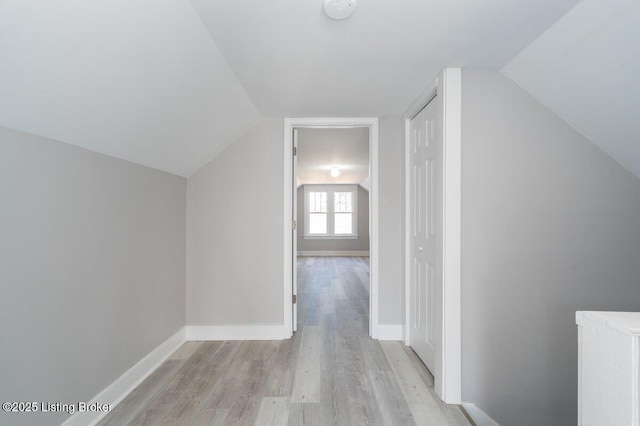 bonus room with vaulted ceiling and light wood-type flooring