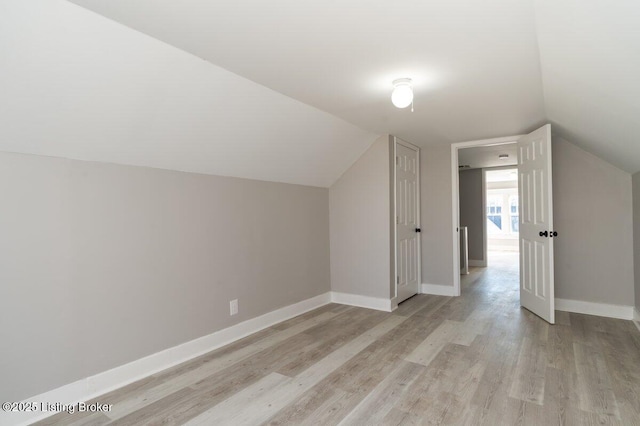 additional living space featuring lofted ceiling and light wood-type flooring